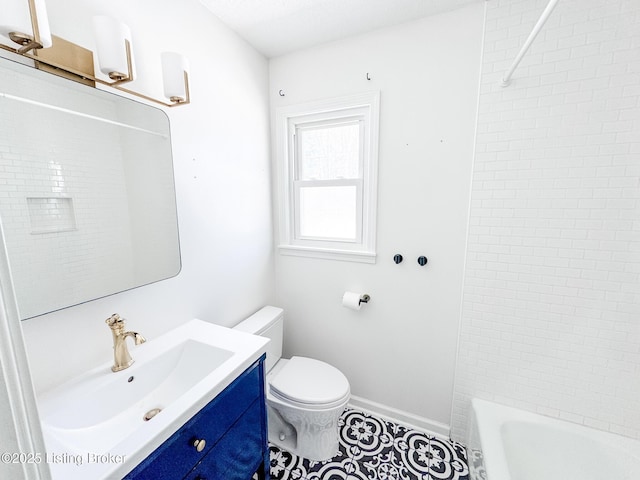 bathroom featuring toilet, baseboards, and vanity