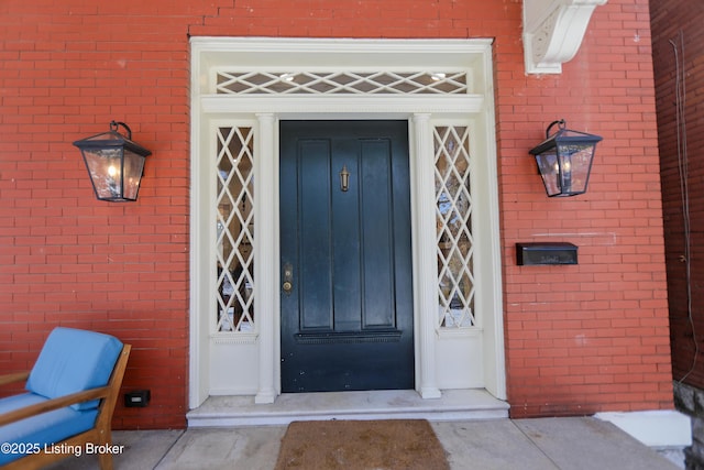 doorway to property featuring brick siding