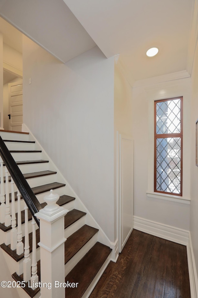 staircase featuring baseboards and wood finished floors