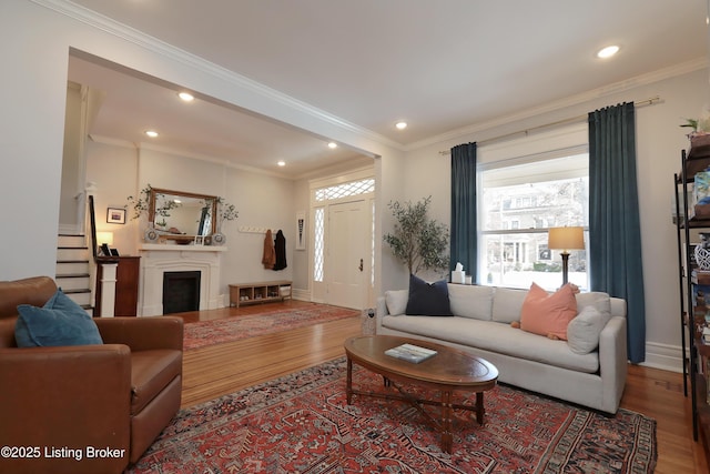 living area featuring baseboards, recessed lighting, wood finished floors, and crown molding