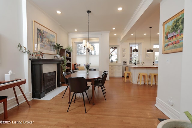 dining space featuring ornamental molding, recessed lighting, light wood-style flooring, and baseboards