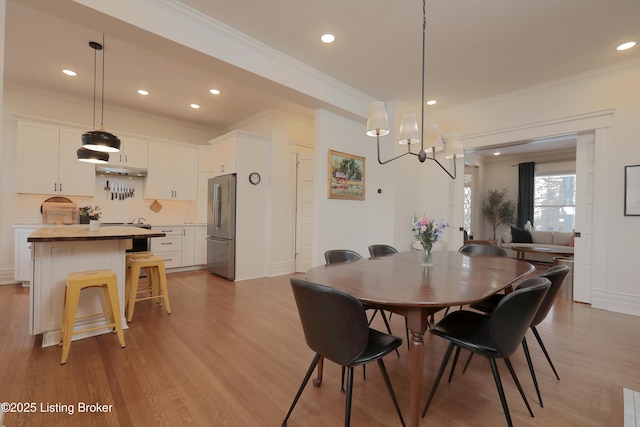 dining room featuring ornamental molding, recessed lighting, and light wood finished floors