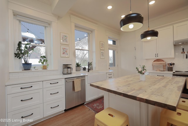 kitchen featuring appliances with stainless steel finishes, a center island, butcher block counters, and white cabinetry