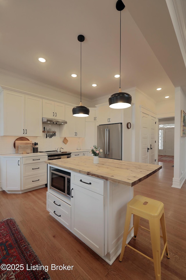 kitchen with stainless steel appliances, light wood-type flooring, a kitchen island, and white cabinets