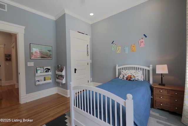 bedroom with visible vents, baseboards, wood finished floors, crown molding, and recessed lighting