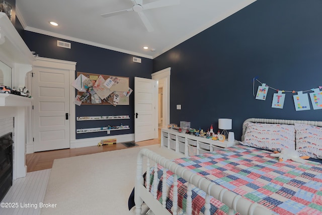 bedroom with ornamental molding, visible vents, and a fireplace