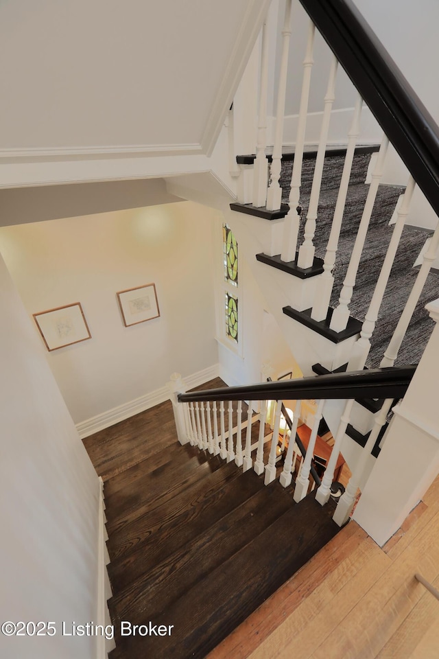 stairway featuring wood finished floors and baseboards