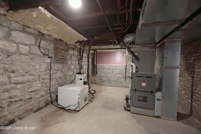 unfinished below grade area with heating unit and fridge