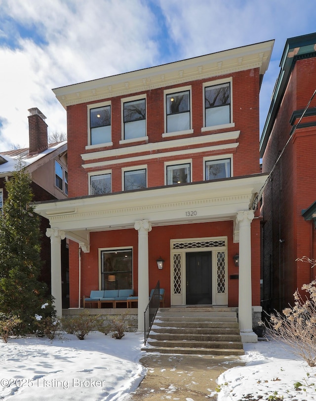 view of front of property featuring covered porch and brick siding