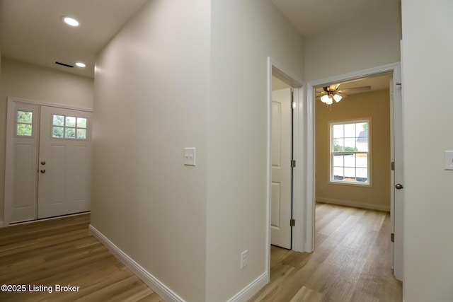 corridor featuring baseboards, recessed lighting, and light wood-style floors