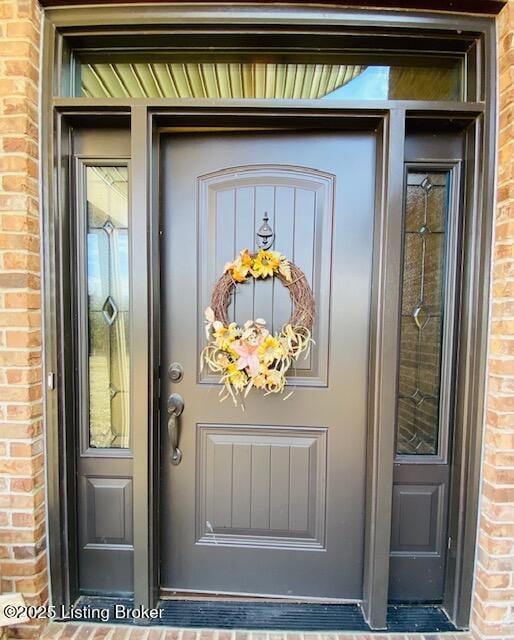 property entrance featuring brick siding