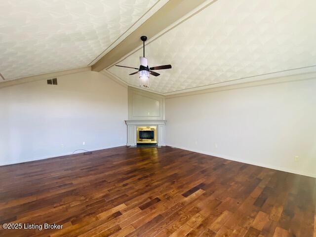 unfurnished living room featuring dark wood-style floors, ceiling fan, a glass covered fireplace, and vaulted ceiling with beams