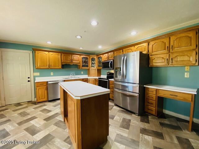 kitchen featuring a kitchen island, glass insert cabinets, brown cabinets, stainless steel appliances, and light countertops