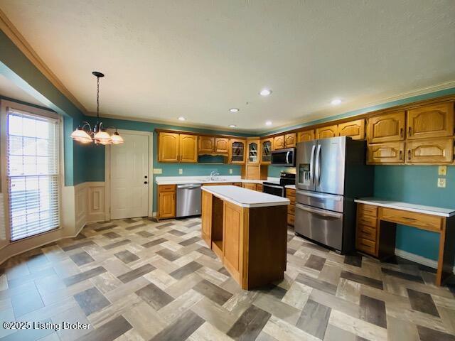 kitchen with stainless steel appliances, light countertops, a center island, brown cabinetry, and glass insert cabinets