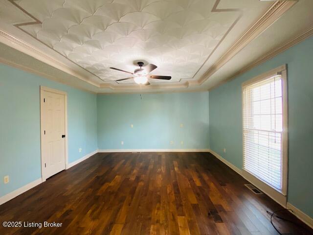 unfurnished room featuring baseboards, visible vents, a tray ceiling, and dark wood-type flooring