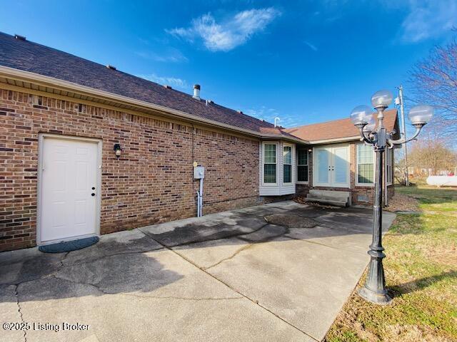 back of house featuring a patio area and brick siding