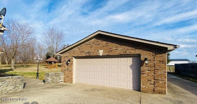 view of side of property featuring brick siding, an outdoor structure, and a detached garage