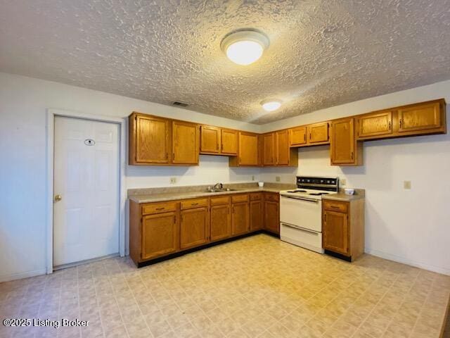 kitchen with light countertops, electric stove, brown cabinets, and light floors