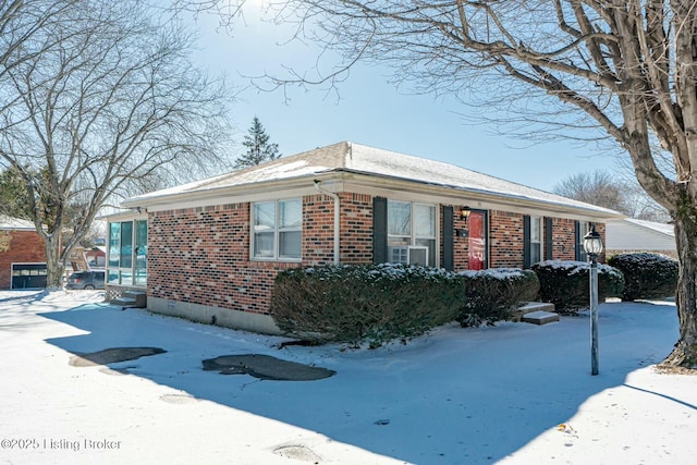 view of snow covered exterior featuring brick siding