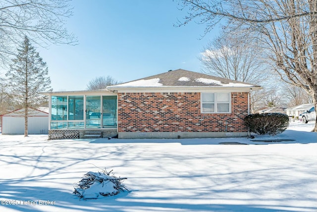 view of front of home featuring a sunroom and brick siding