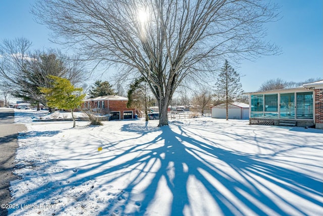 yard covered in snow featuring a sunroom