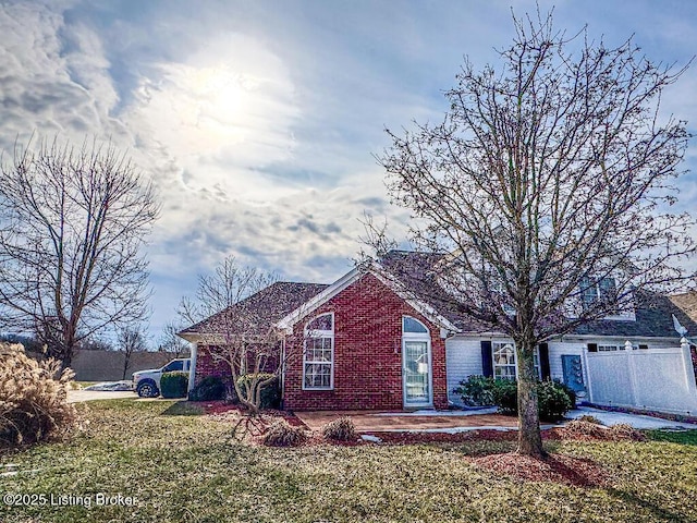 ranch-style home with a patio area, brick siding, and a front yard