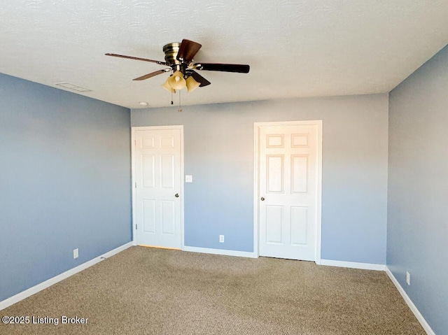 unfurnished bedroom with ceiling fan, carpet floors, a textured ceiling, and baseboards