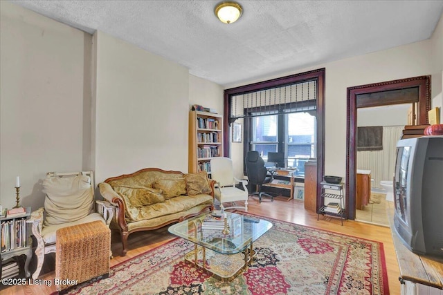 living area with a textured ceiling and wood finished floors