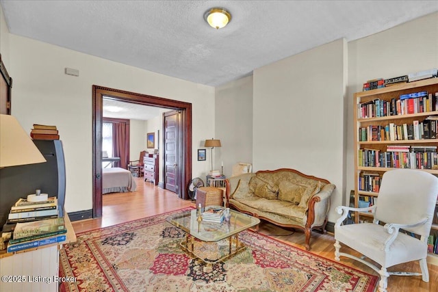 living room featuring light wood-style flooring and a textured ceiling