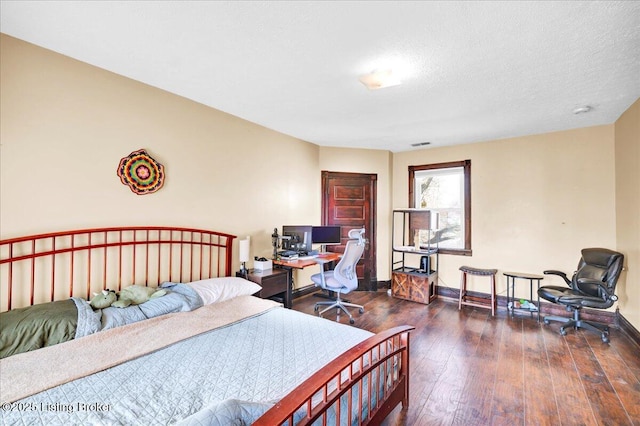 bedroom featuring dark wood-type flooring, a textured ceiling, and baseboards