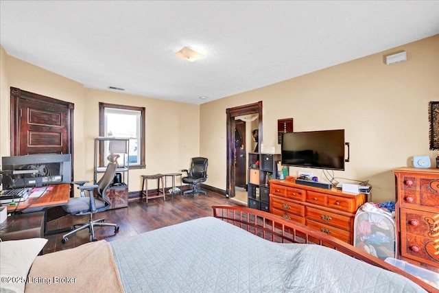 bedroom featuring dark wood-style flooring, visible vents, and baseboards