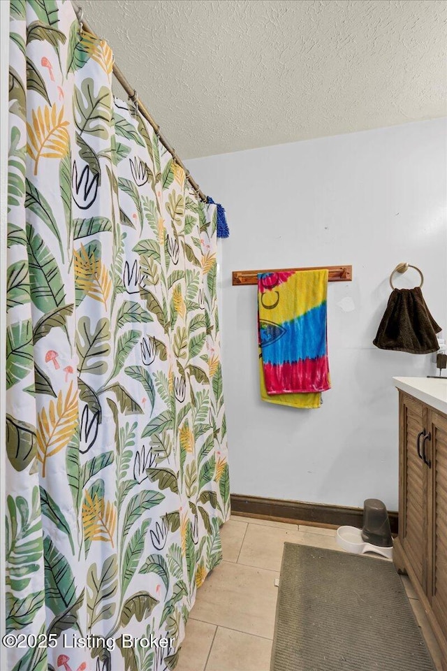 full bathroom featuring baseboards, vanity, and a textured ceiling