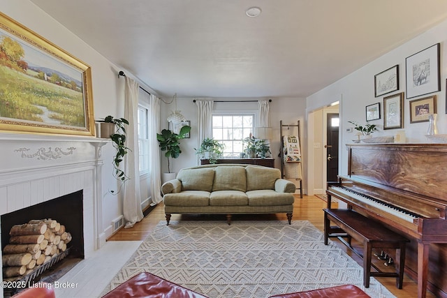 living room with a fireplace with flush hearth and light wood finished floors