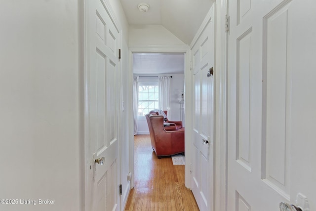 hall with lofted ceiling and light wood finished floors