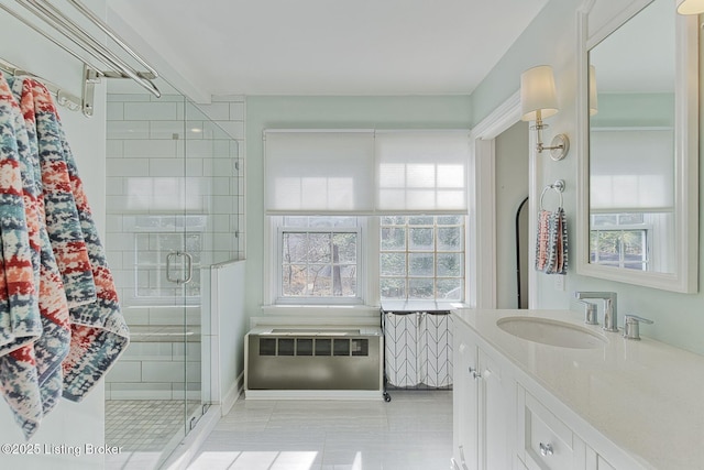 bathroom featuring a healthy amount of sunlight, a shower stall, vanity, and radiator