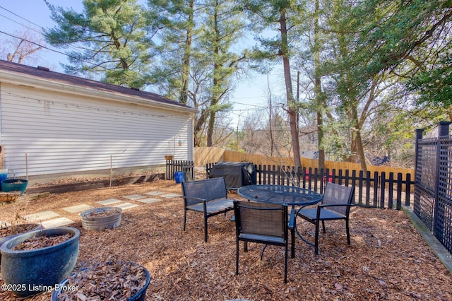 view of yard featuring a fenced backyard and outdoor dining space