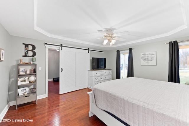 bedroom featuring a barn door, wood finished floors, a ceiling fan, and baseboards