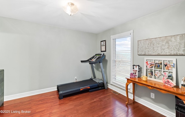 workout room with wood-type flooring and baseboards