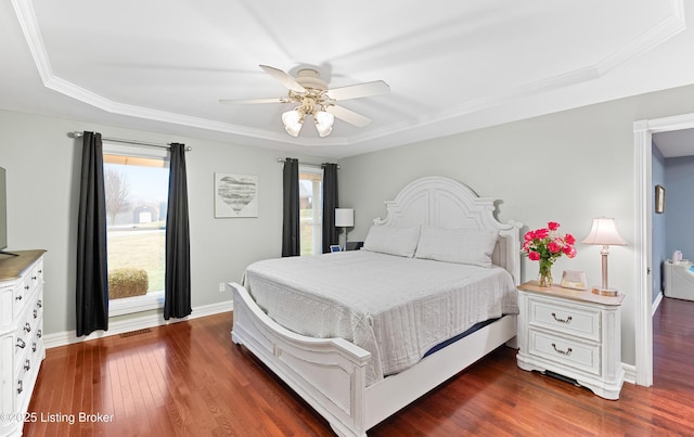 bedroom with dark wood-style flooring, multiple windows, and baseboards