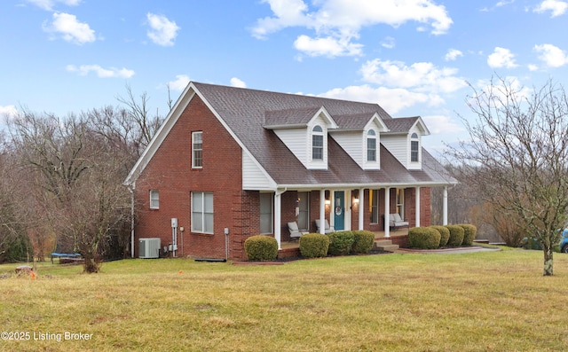 new england style home with covered porch, central AC, brick siding, and a front yard