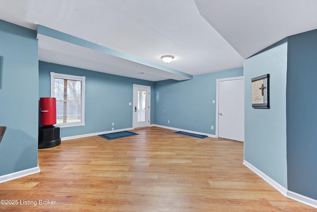 spare room featuring plenty of natural light, light wood-style flooring, and baseboards