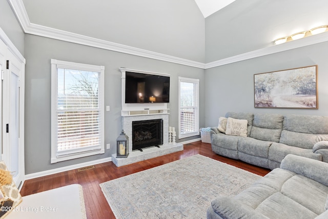 living room with baseboards, dark wood-style flooring, a fireplace, and a healthy amount of sunlight