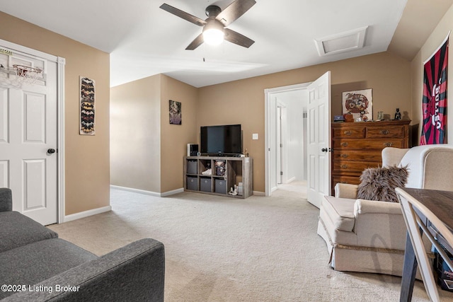 living room with attic access, a ceiling fan, carpet flooring, vaulted ceiling, and baseboards