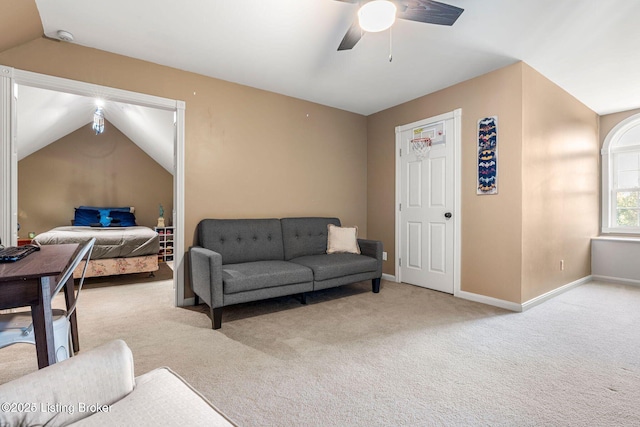 living room with light carpet, ceiling fan, vaulted ceiling, and baseboards