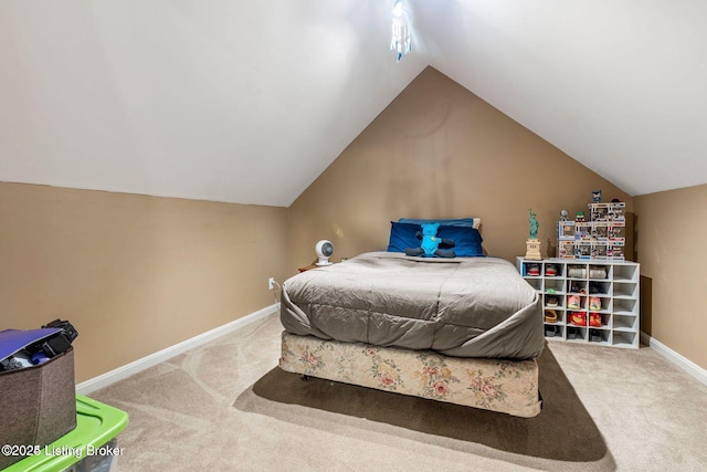 bedroom with lofted ceiling, carpet, and baseboards