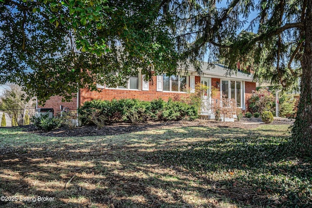 ranch-style home with brick siding and a front yard