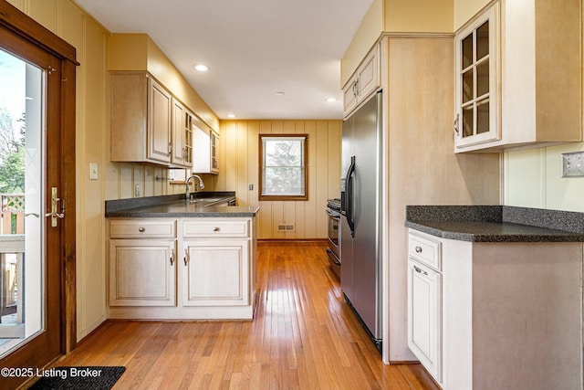 kitchen with recessed lighting, stainless steel appliances, a sink, light wood-style floors, and glass insert cabinets