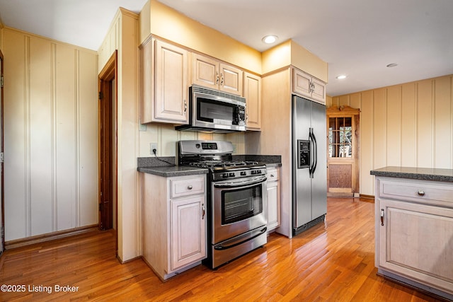 kitchen with stainless steel appliances, dark countertops, light wood-style flooring, and recessed lighting