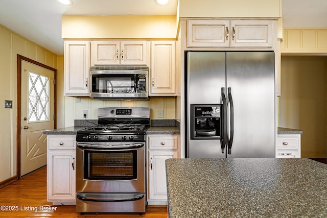 kitchen with dark countertops, appliances with stainless steel finishes, and wood finished floors