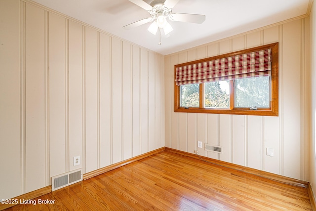 unfurnished room with a ceiling fan, visible vents, and light wood-style floors